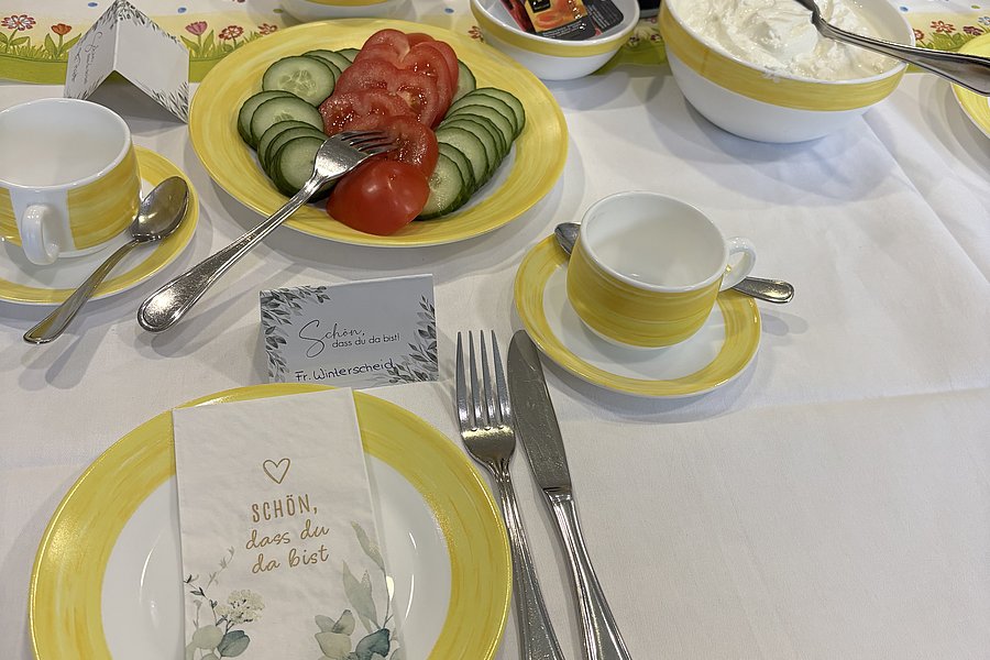 Tischdeko mit gelbem Porzellan, frischem Gemüse und Desserts, serviert für eine festliche Gelegenheit.