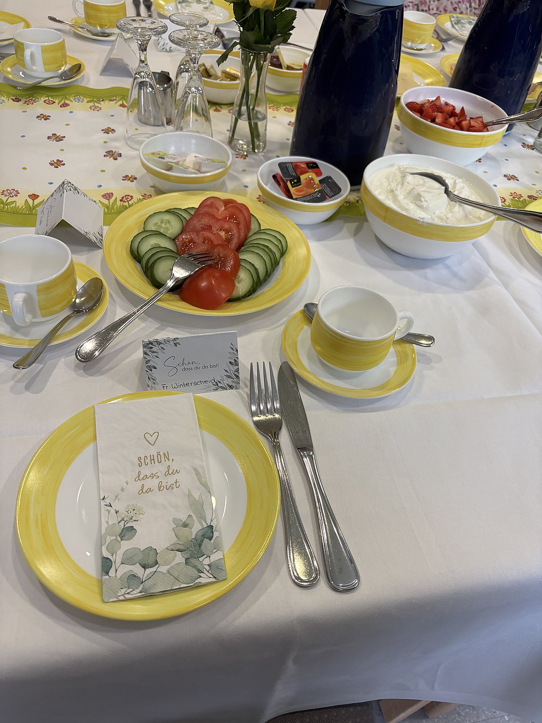 Tischdeko mit gelbem Porzellan, frischem Gemüse und Desserts, serviert für eine festliche Gelegenheit.